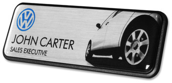 A black border prestige name badge brushed design with silver background with the leyend: "John Carter"